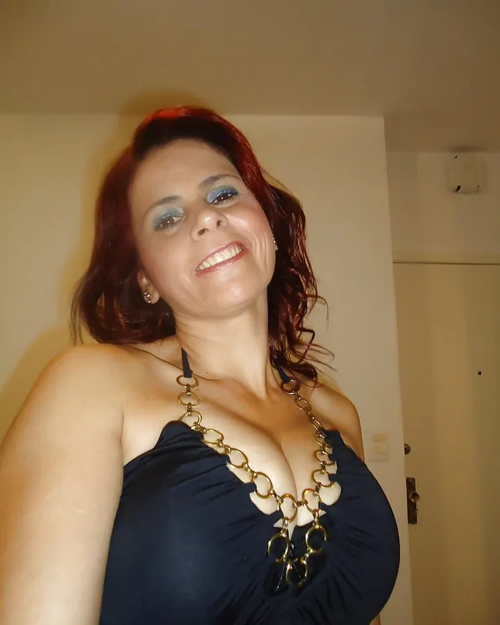 Femme aux cheveux bruns portant un haut blanc et noir, posant de profil avec un regard vers le côté, devant un fond naturel.