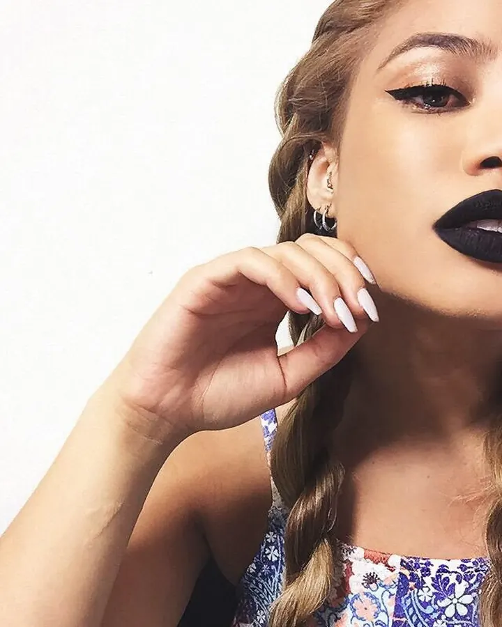 Femme latine aux cheveux blonds, regardant l'objectif avec un sourire engageant.